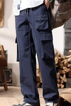 NEWYORKLISTED ATLAS MEN's COLLECTION: Person wearing navy cargo pants with a blurred background