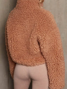 NEWYORKLISTED STYLE COLLECTION: Person wearing a brown sherpa jacket against a neutral background