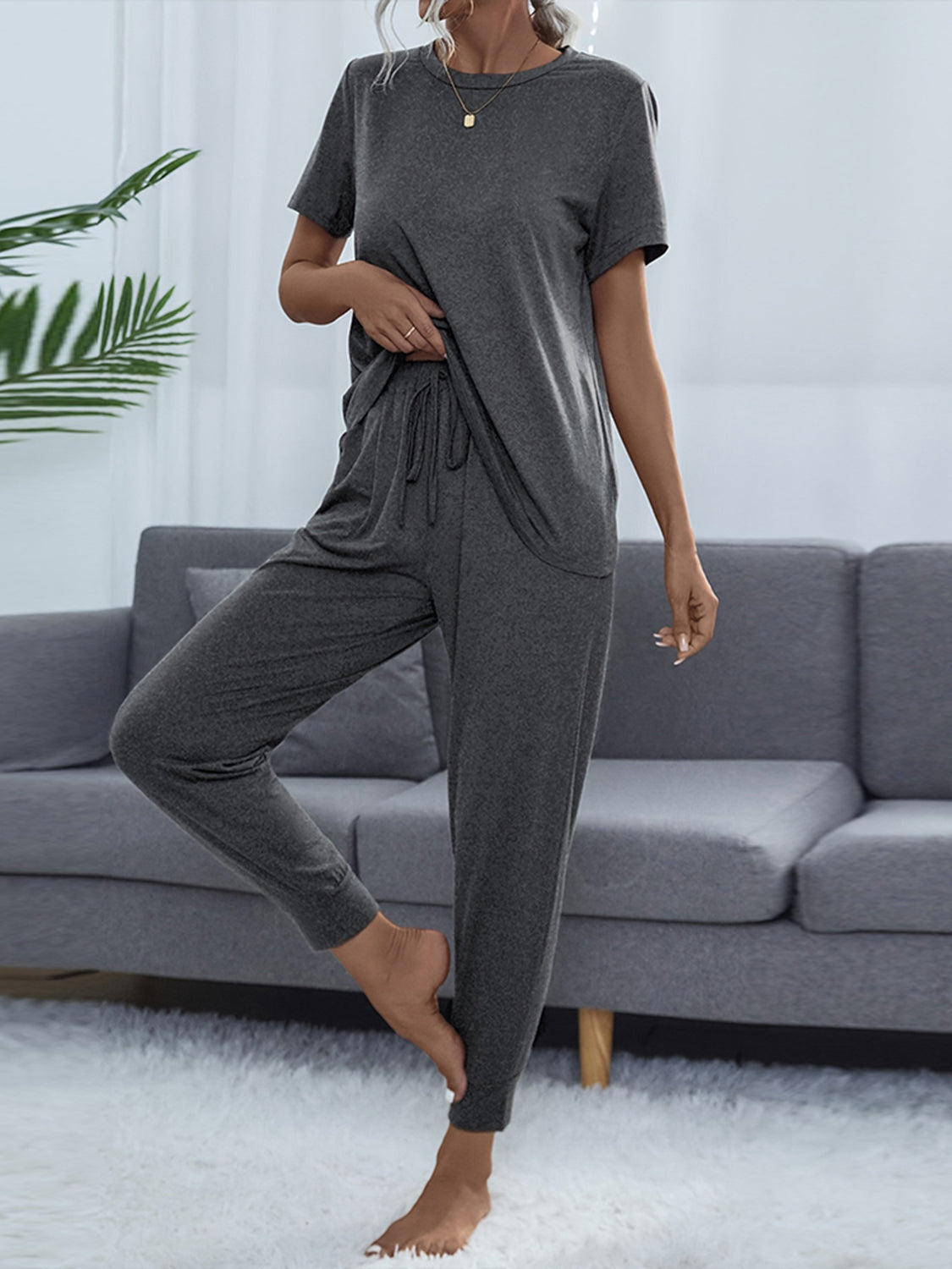 NEWYORKLISTED Intimate Apparel: Person wearing a gray pajama set in a living room.