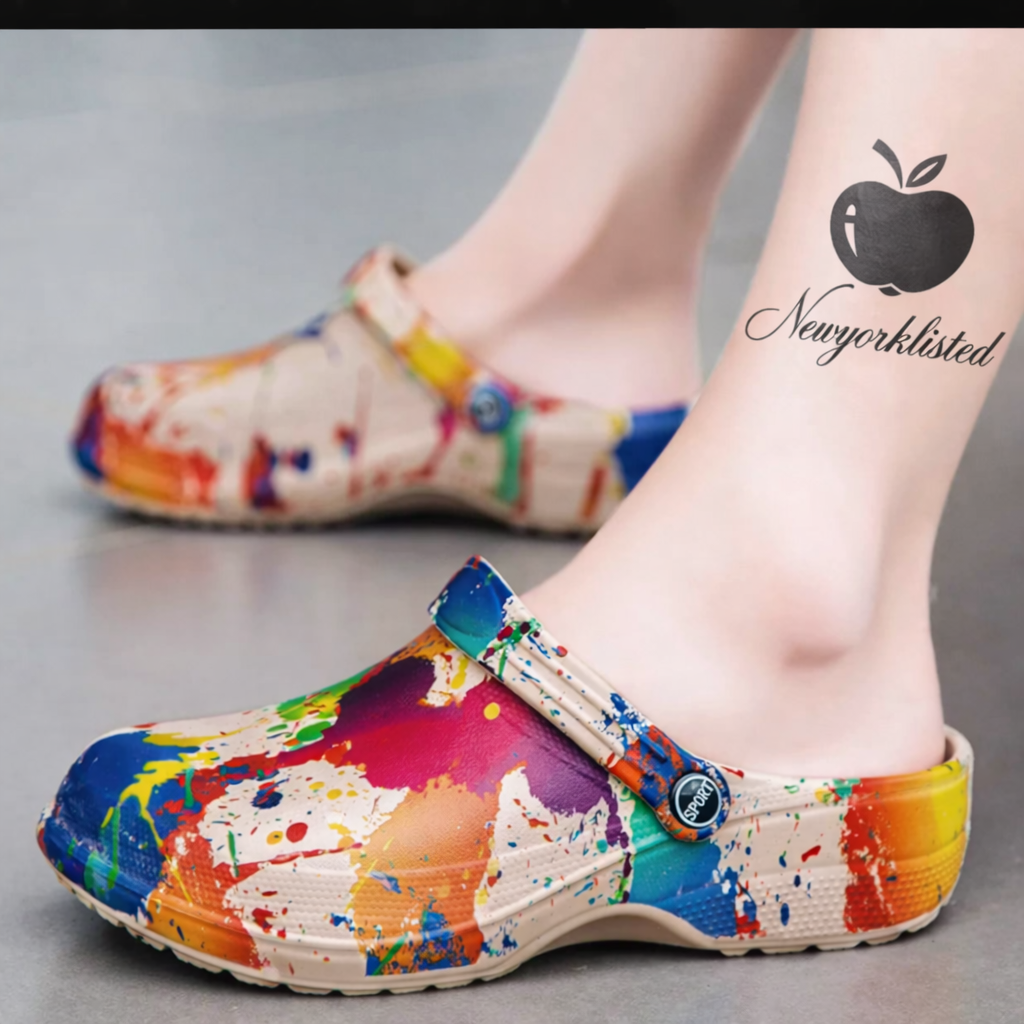 NEWYORKLISTED SHOE COLLECTION: Colorful splatter-patterned clogs worn by a person with a visible tattoo on their leg. 