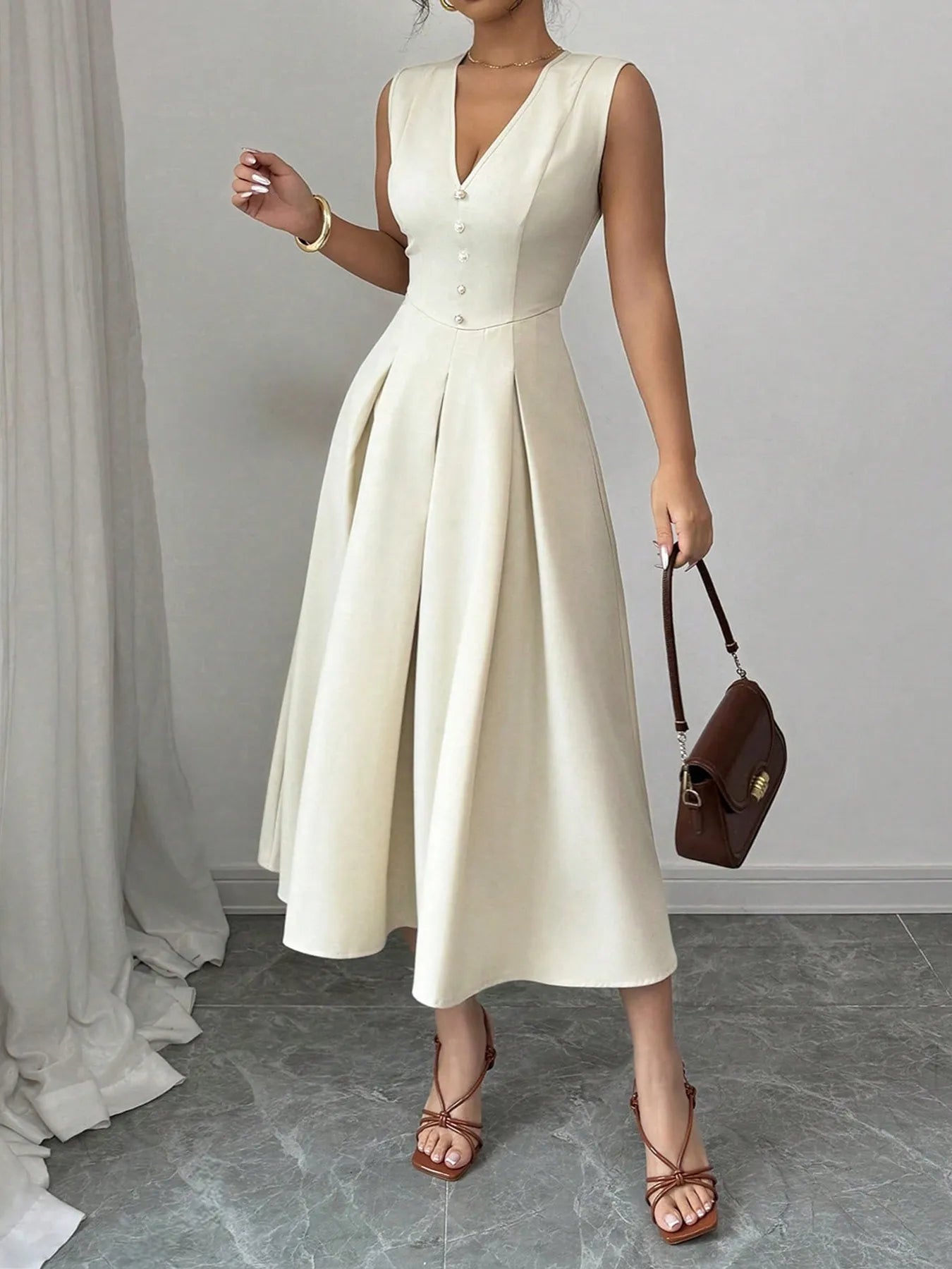Light cream sleeveless V-neck midi dress with pearl buttons and pleated A-line skirt — NEWYORKLISTED STYLE COLLECTION.