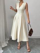 Light cream sleeveless V-neck midi dress with pearl buttons and pleated A-line skirt — NEWYORKLISTED STYLE COLLECTION.