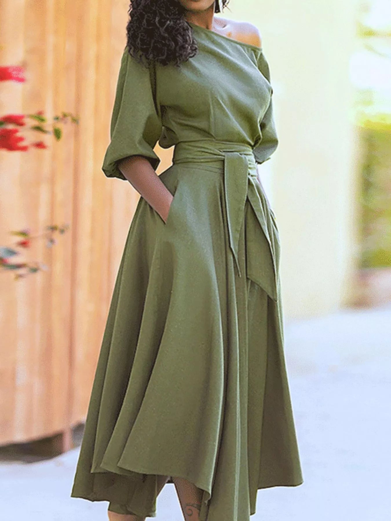 NEWYORKLISTED STYLE COLLECTION: Woman wearing a green dress with a blurred background