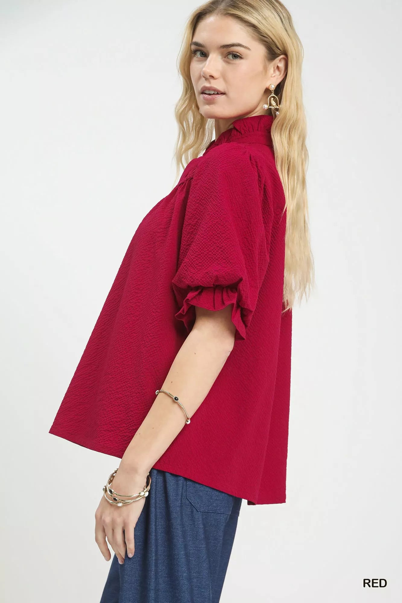 NEWYORKLISTED Style Collection: Woman wearing a red blouse with ruffled sleeves on a white background