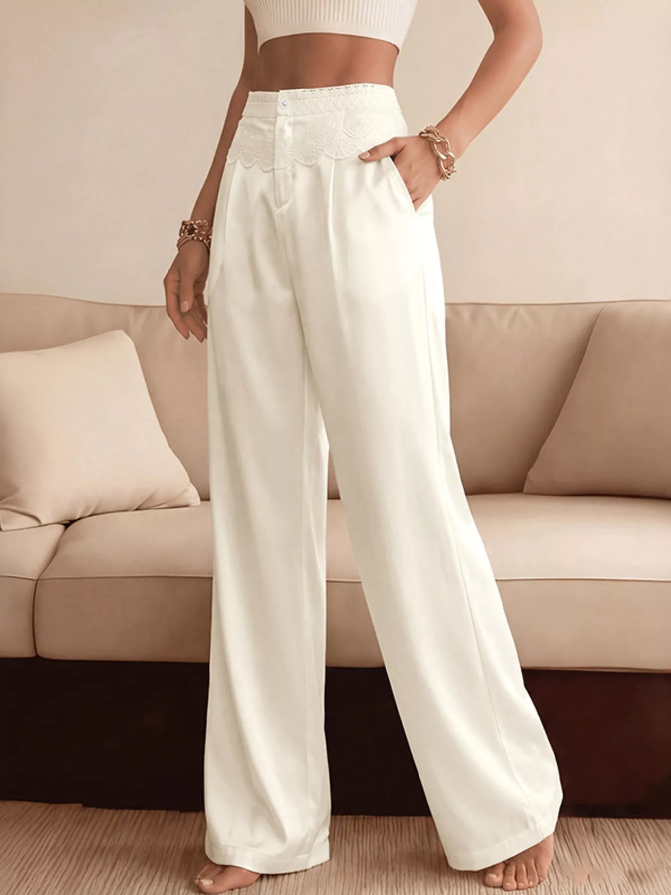 NEWYORKLISTED STYLE COLLECTION: Person wearing white wide-leg pants standing in a living room.