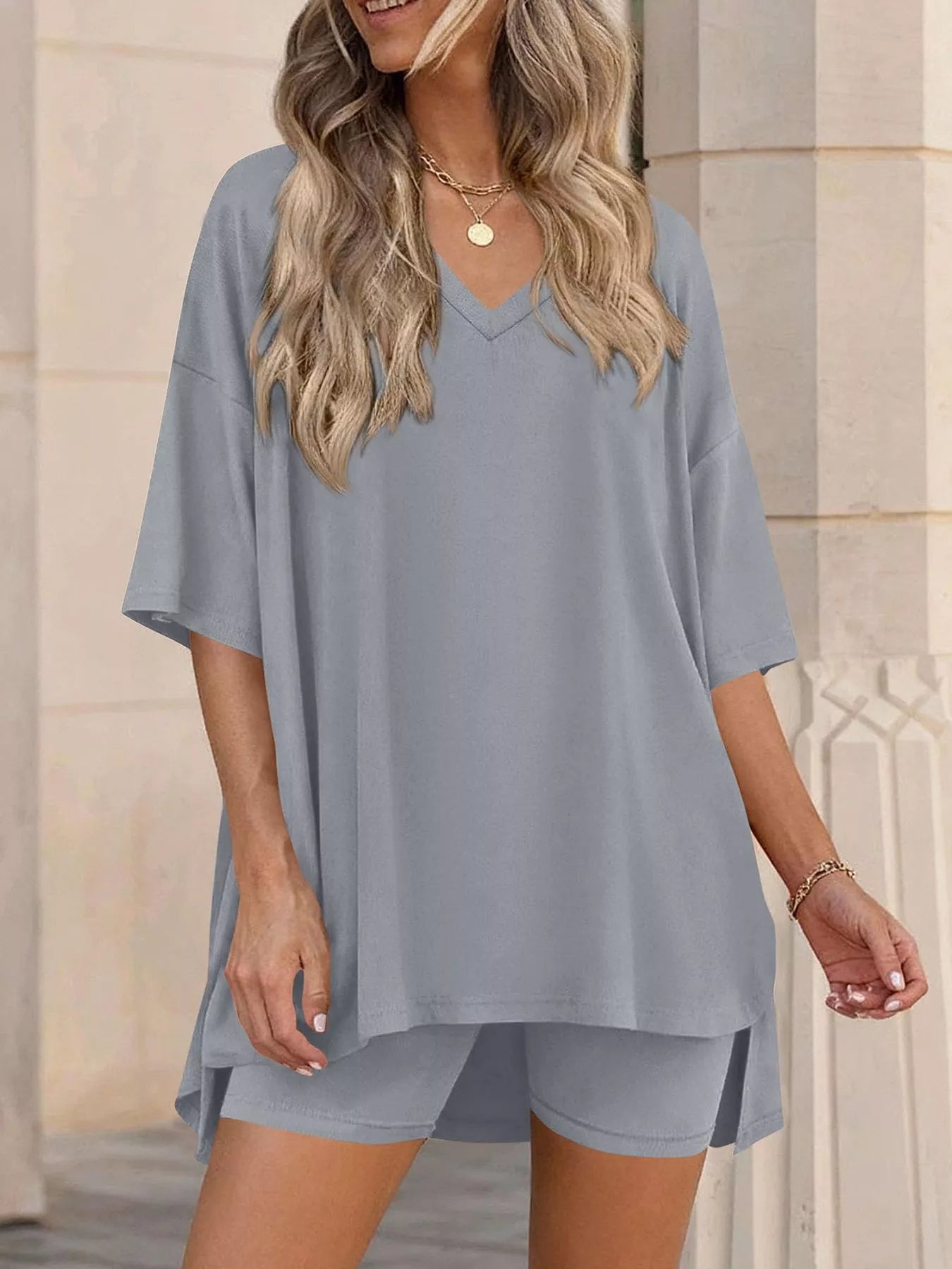 NEWYORKLISTED COMFORT COLLECTION: Woman wearing a gray oversized t-shirt and shorts set against a neutral background