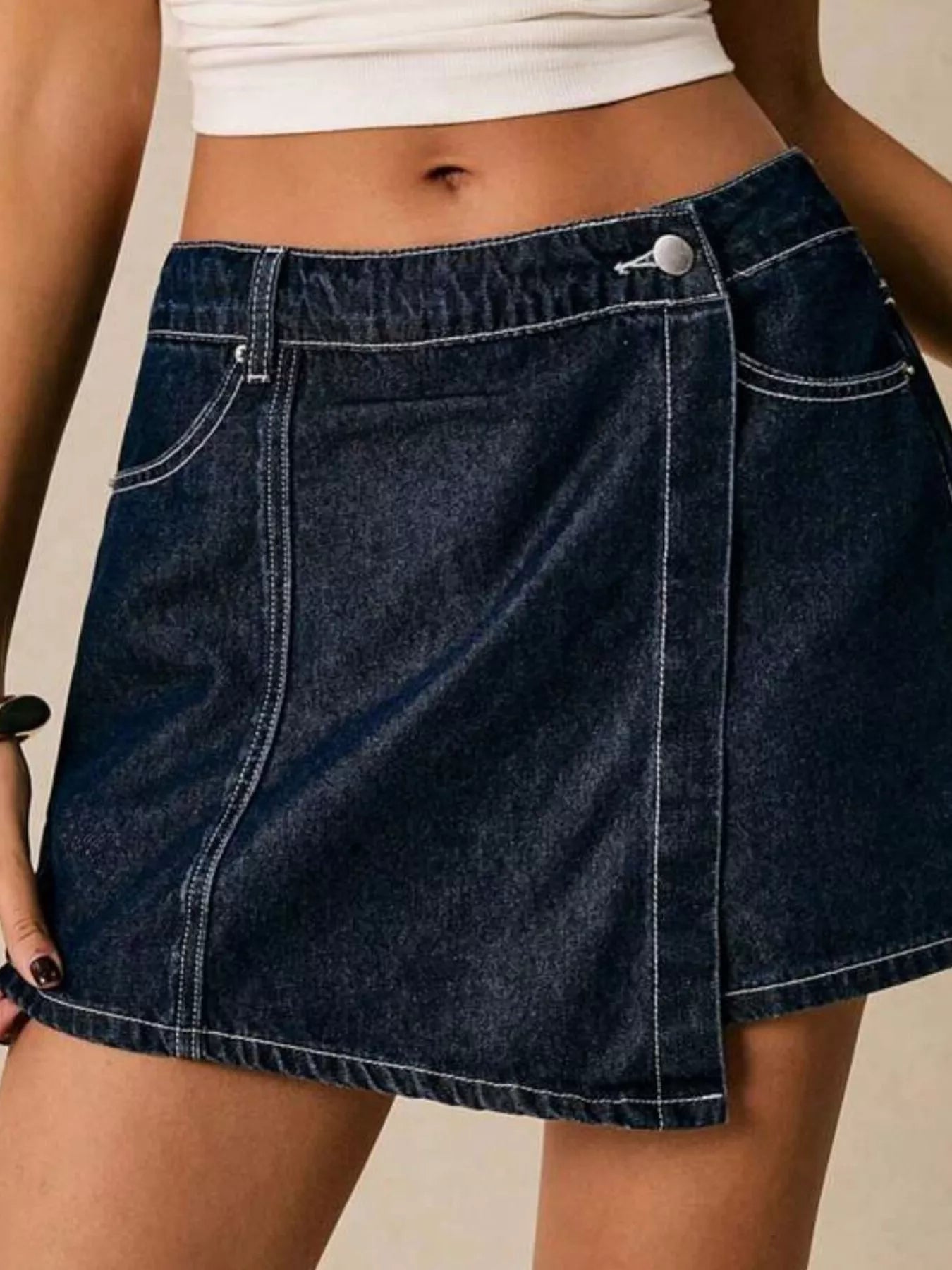 NEWYORKLISTED STYLE COLLECTION: Person wearing a blue denim skirt on a neutral background