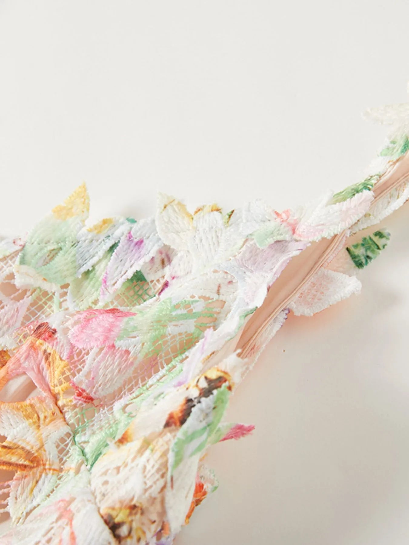 NEWYORKLISTED STYLE COLLECTION: Close-up of colorful floral-patterned fabric on a light background