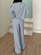 NEWYORKLISTED Comfort Collection: Person wearing a blue and white striped outfit standing on a wooden floor.