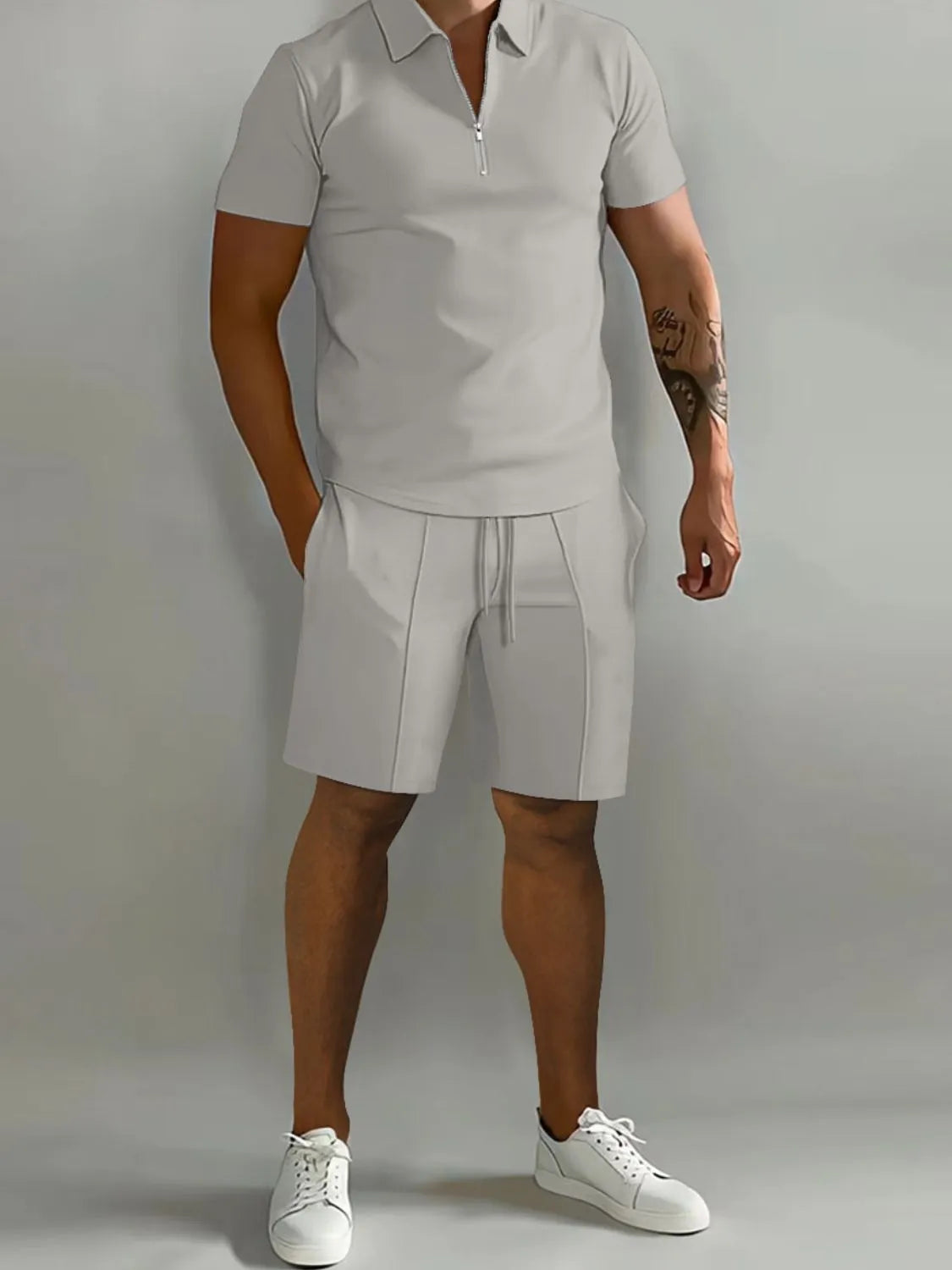 NEWYORKLISTED ATLAS MEN's COLLECTION: Male model wearing a gray polo shirt and shorts set with white sneakers on a plain background