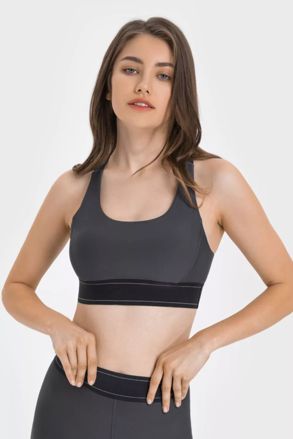 NEWYORKLISTED ACTIVEWEAR COLLECTION: Woman wearing a black sports bra and leggings on a white background