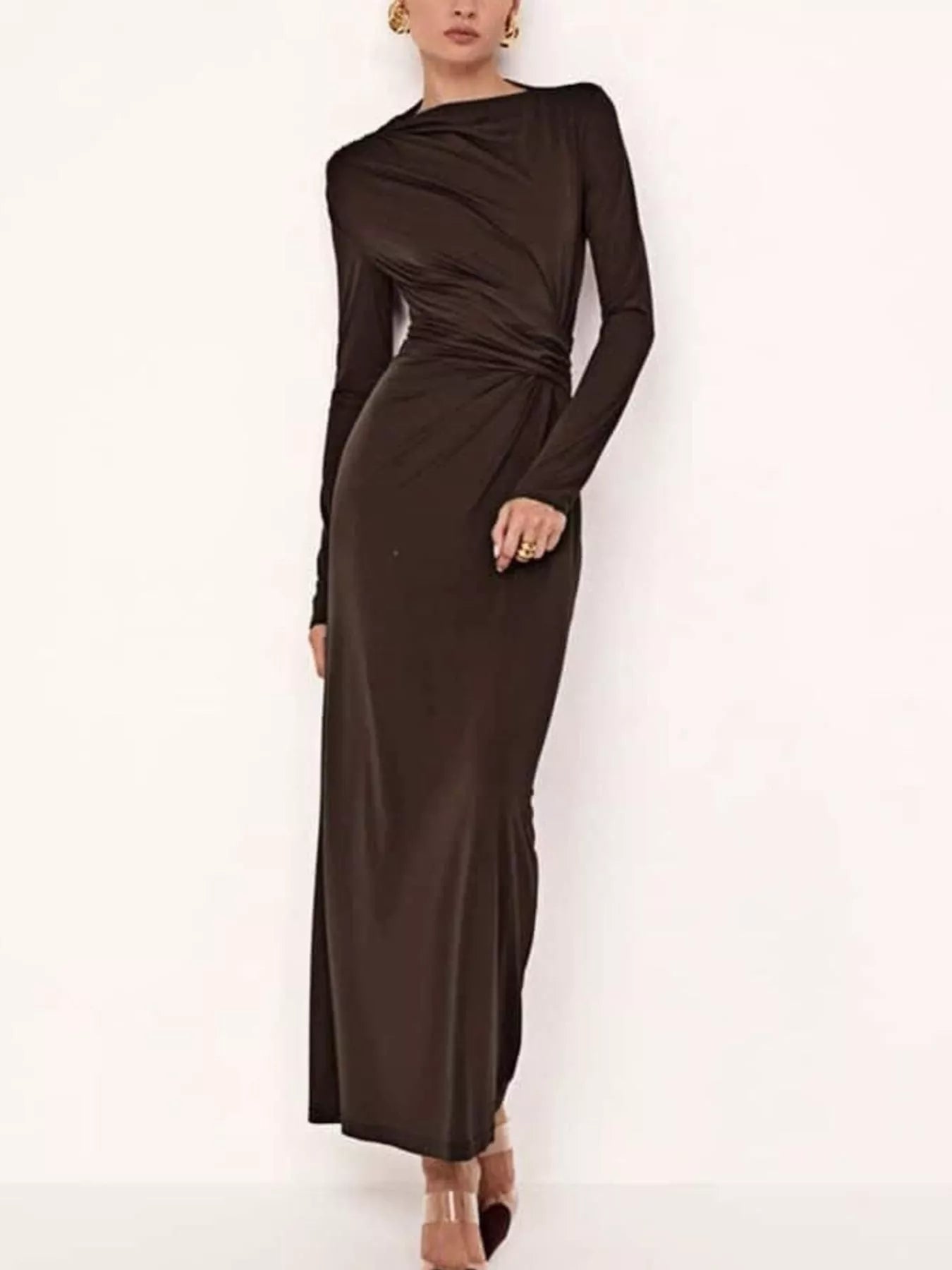 NEWYORKLISTED STYLE COLLECTION: Woman wearing a long brown dress against a white background