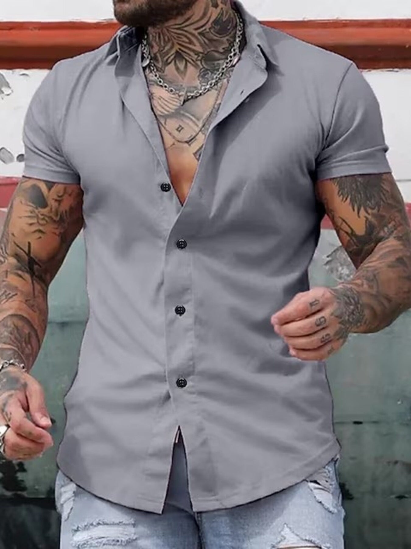 NEWYORKLISTED ATLAS MEN's COLLECTION: Man wearing a gray button-up shirt with tattoos on his arms.