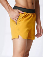 NEWYORKLISTED ATLAS MEN's COLLECTION: Yellow athletic shorts with black waistband on a white background