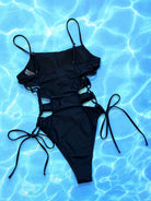 NEWYORKLISTED Eden Collection: Black swimsuit on a blue water background