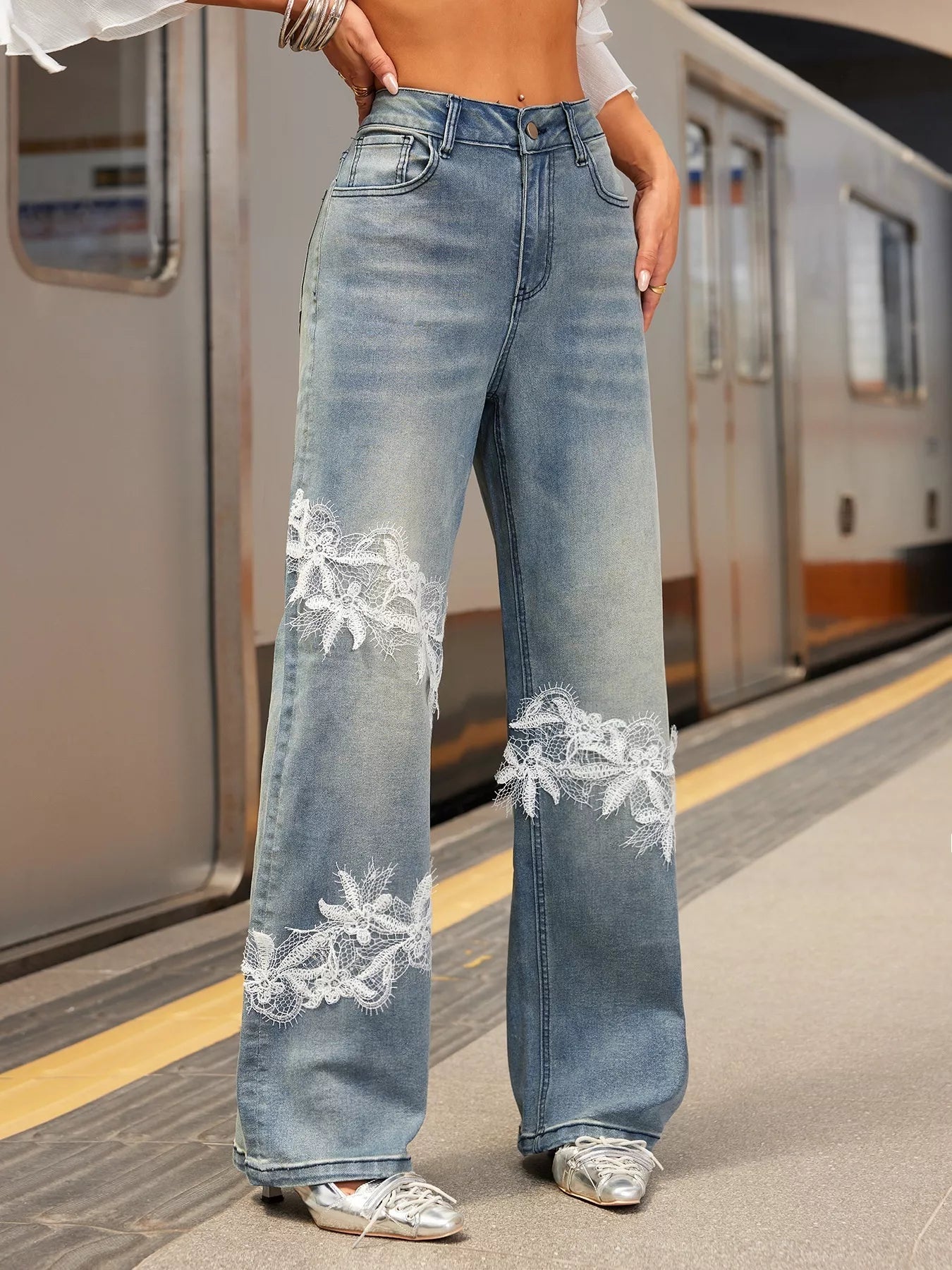 NEWYORKLISTED STYLE COLLECTION: Person wearing blue jeans with lace detailing on a subway platform
