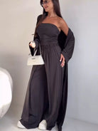 NEWYORKLISTED COMFORT COLLECTION: Woman wearing a dark gray off-shoulder dress with long sleeves against a plain background
