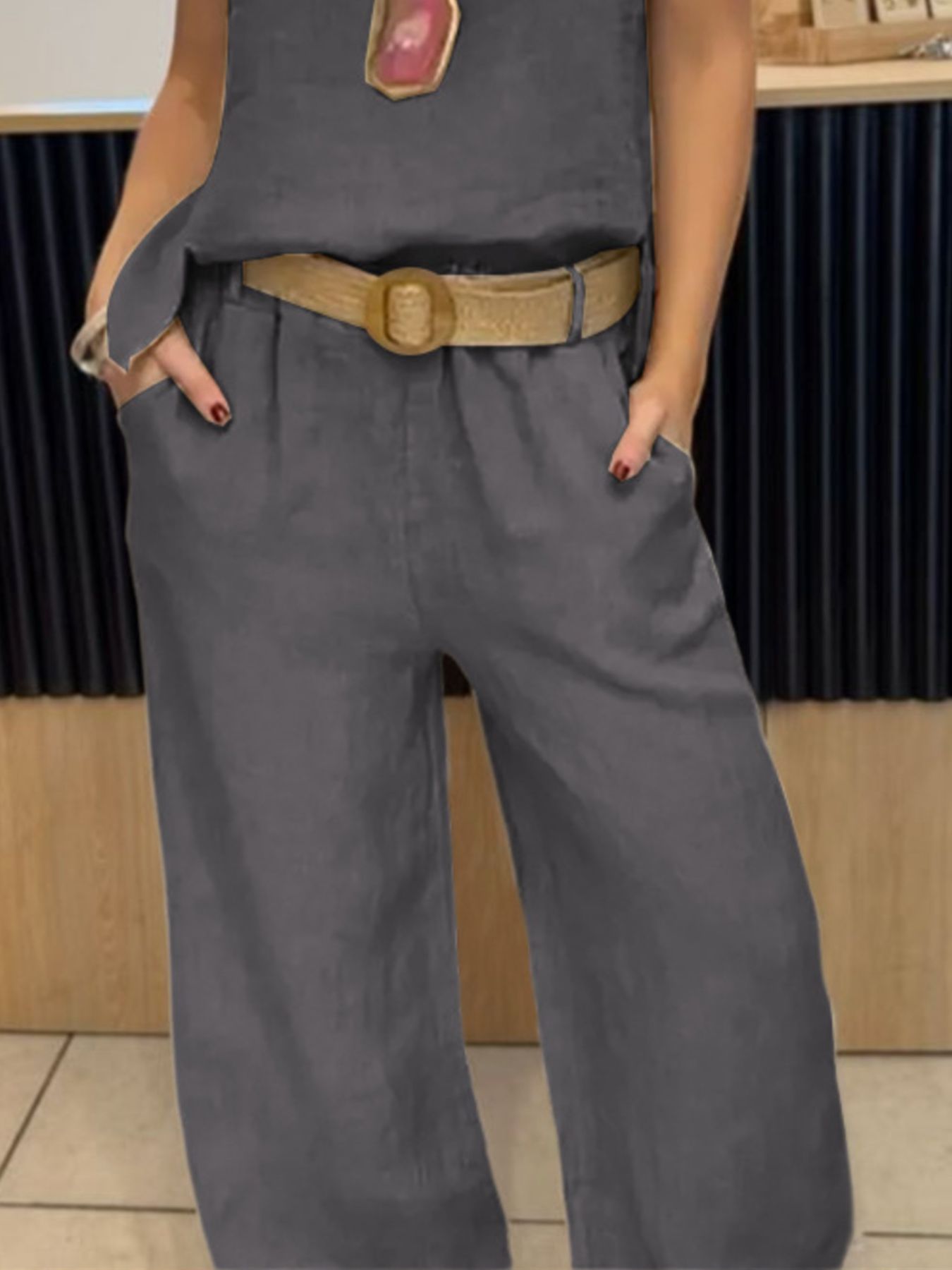 NEWYORKLISTED COMFORT COLLECTION: Person wearing a gray outfit with a belt in an indoor setting