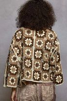 Person wearing a patterned jacket with a gray background