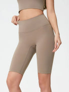 Person wearing beige athletic shorts on a plain background