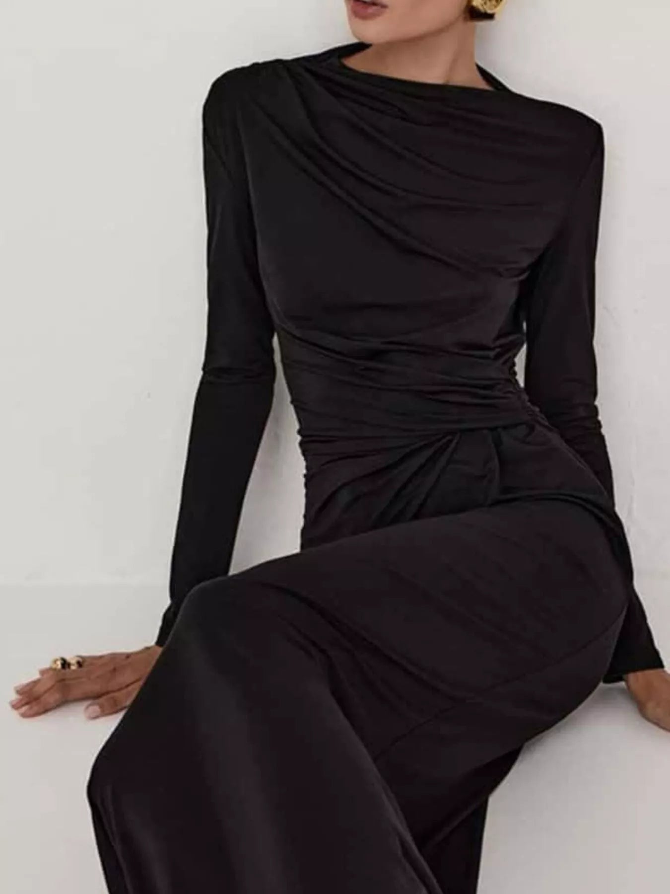 NEWYORKLISTED STYLE COLLECTION: Model is wearing a black long-sleeve dress against a white background