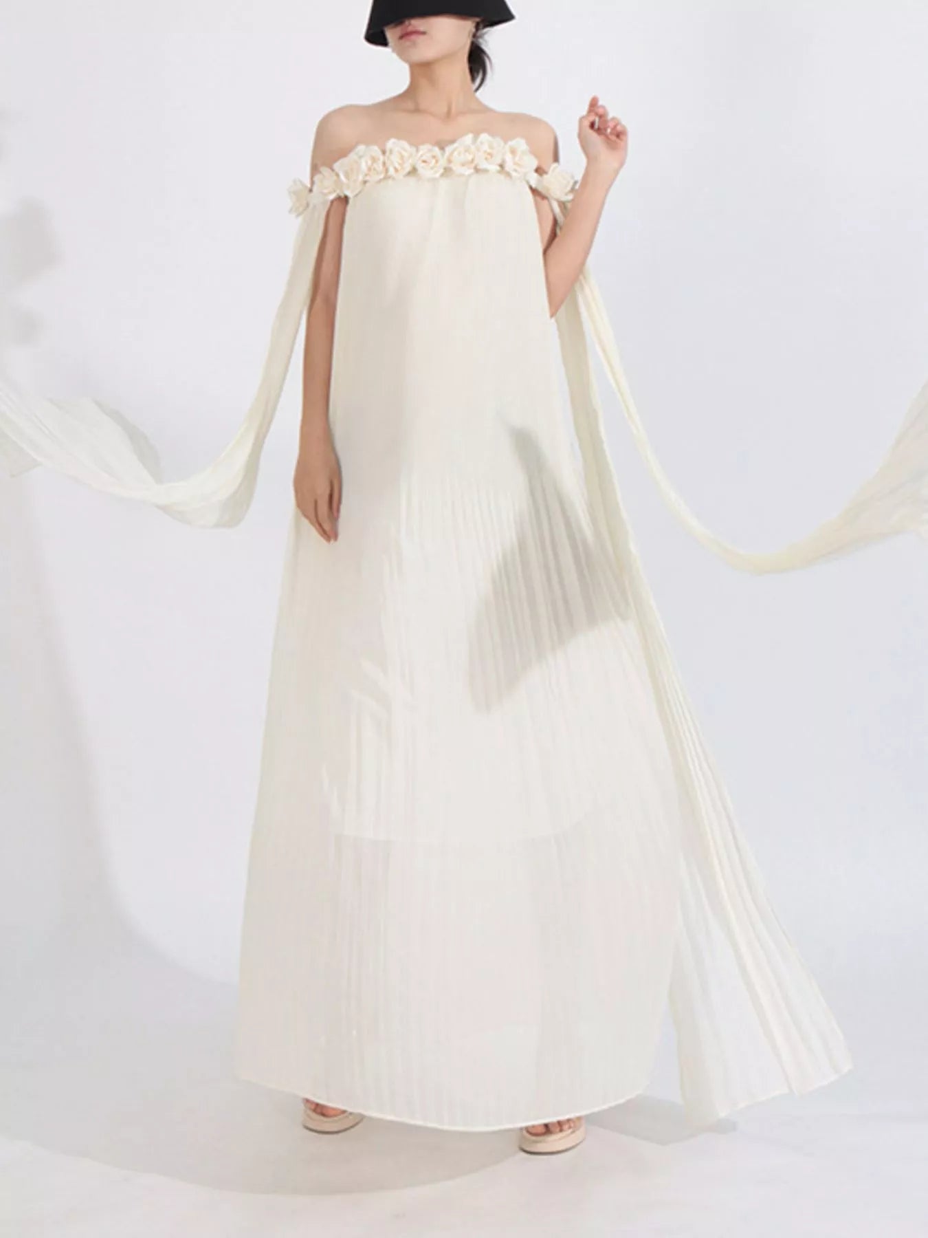 NEWYORKLISTED STYLE COLLECTION: Woman wearing a white strapless dress with floral details on a white background