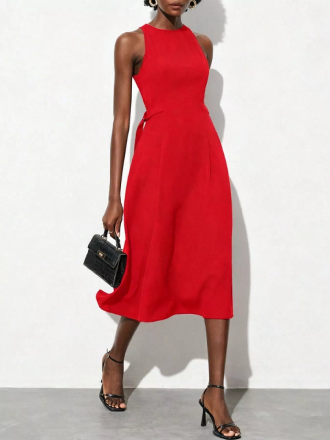 NEWYORKLISTED STYLE COLLECTION: Red sleeveless dress worn by a model on a white background