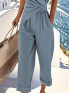 NEWYORKLISTED STYLE COLLECTION: Person wearing a light blue jumpsuit by a waterfront.