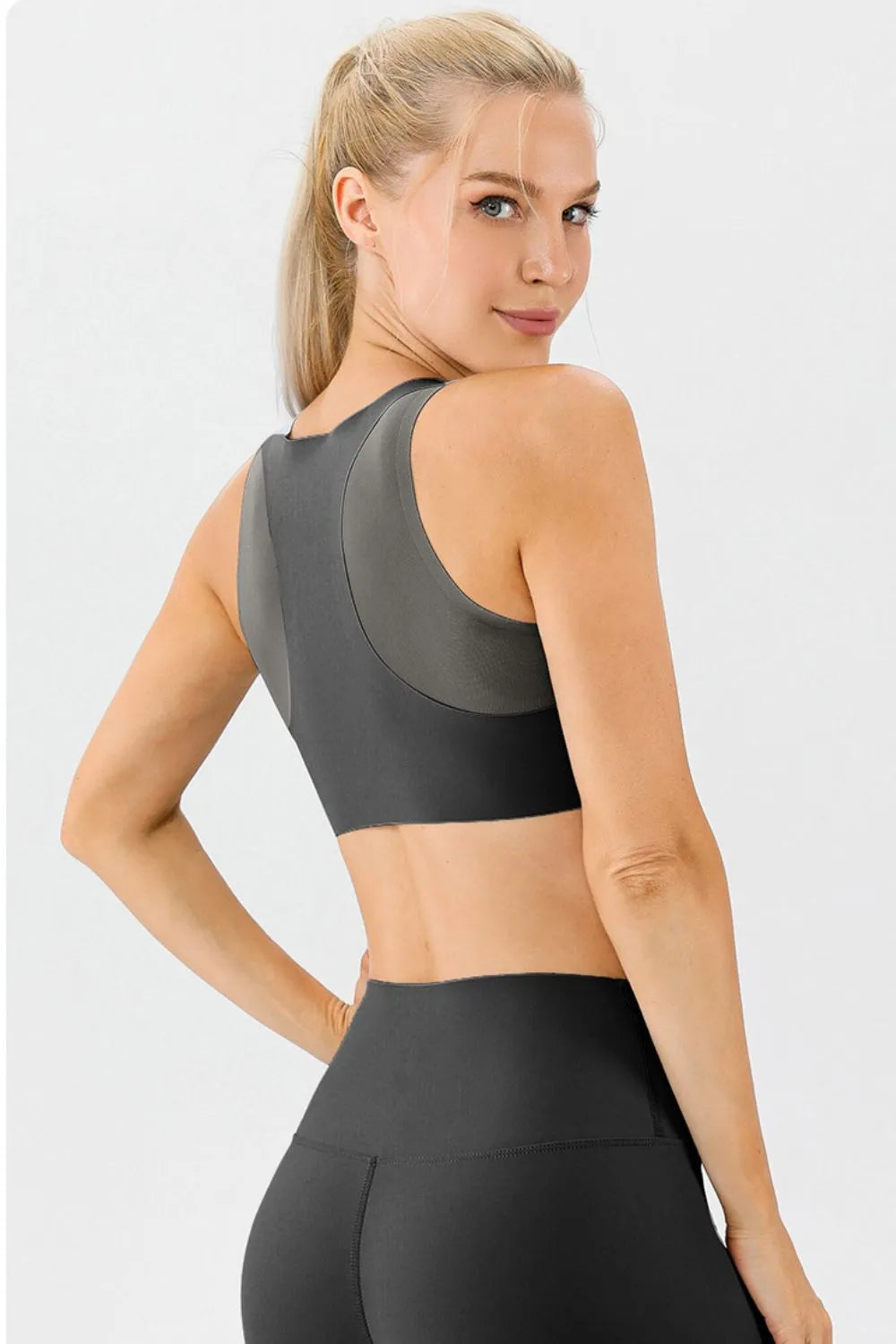 NEWYORKLISTED ACTIVEWEAR COLLECTION: Woman wearing a black sports bra and leggings on a light gray background