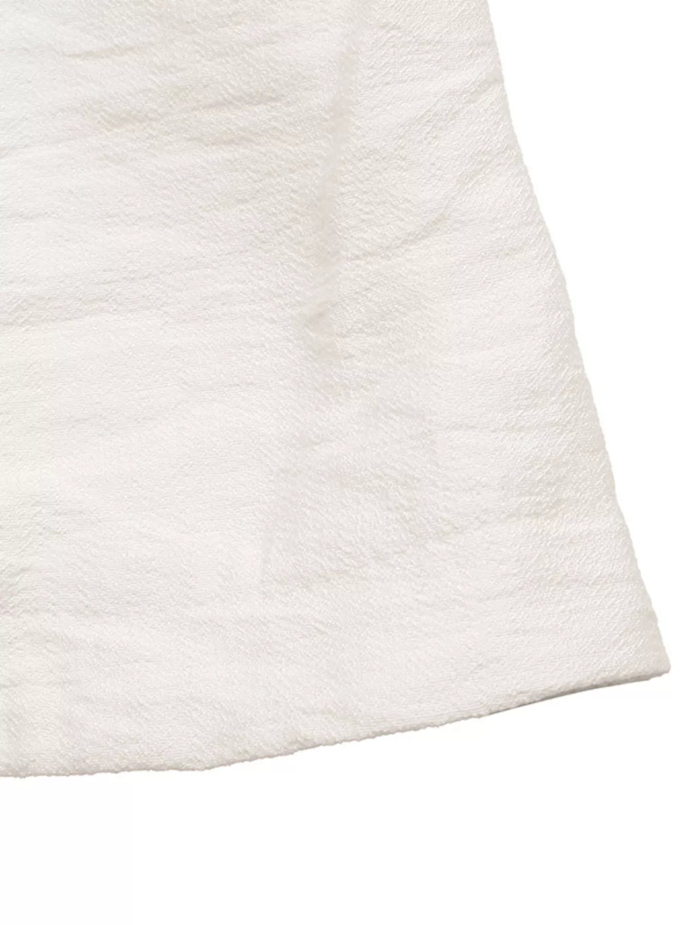 NEWYORKLISTED STYLE COLLECTION: Close-up of a textured white fabric corner on a white background