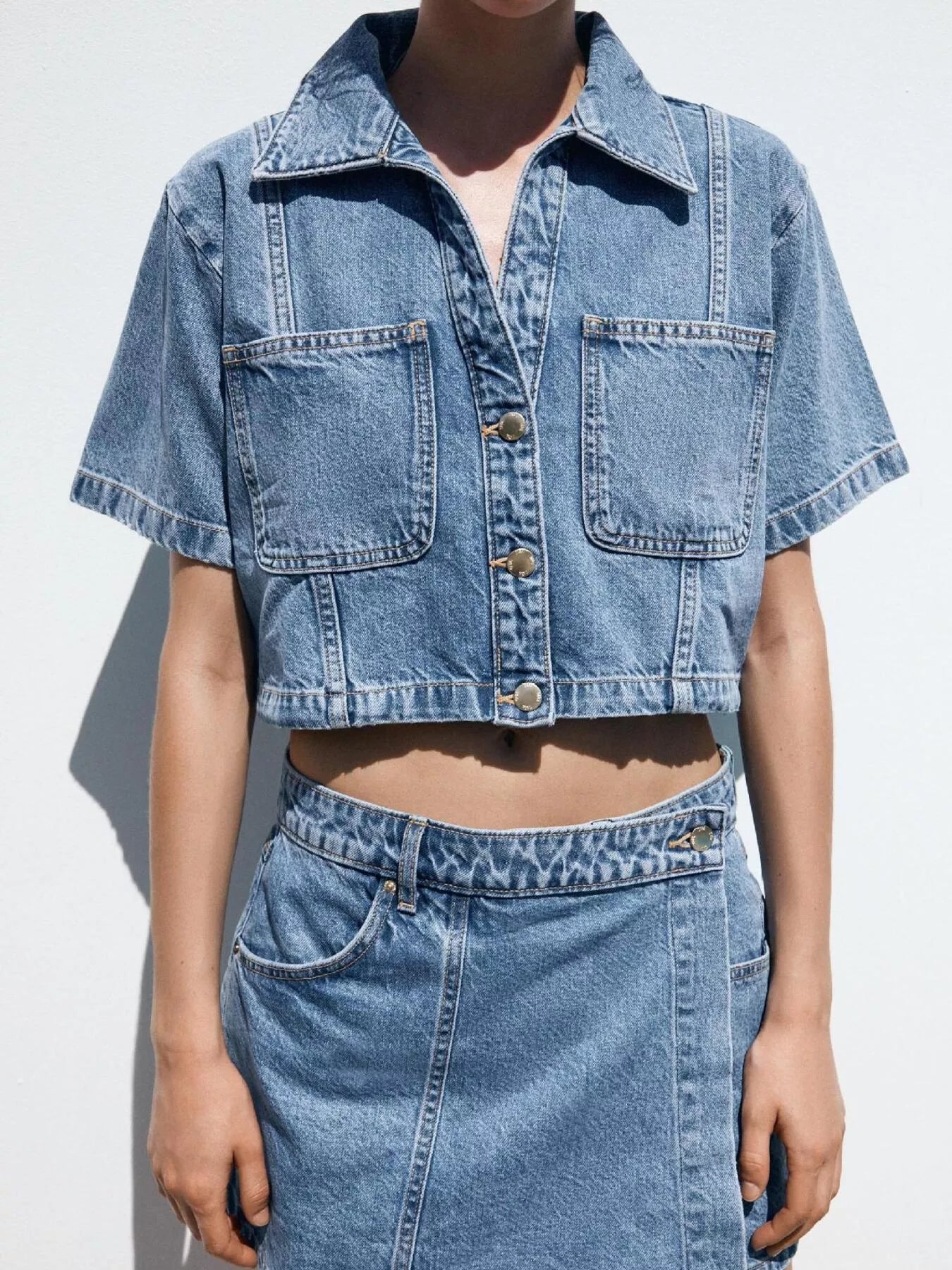 NEWYORKLISTED STYLE COLLECTION: Person wearing a denim jacket and skirt on a white background