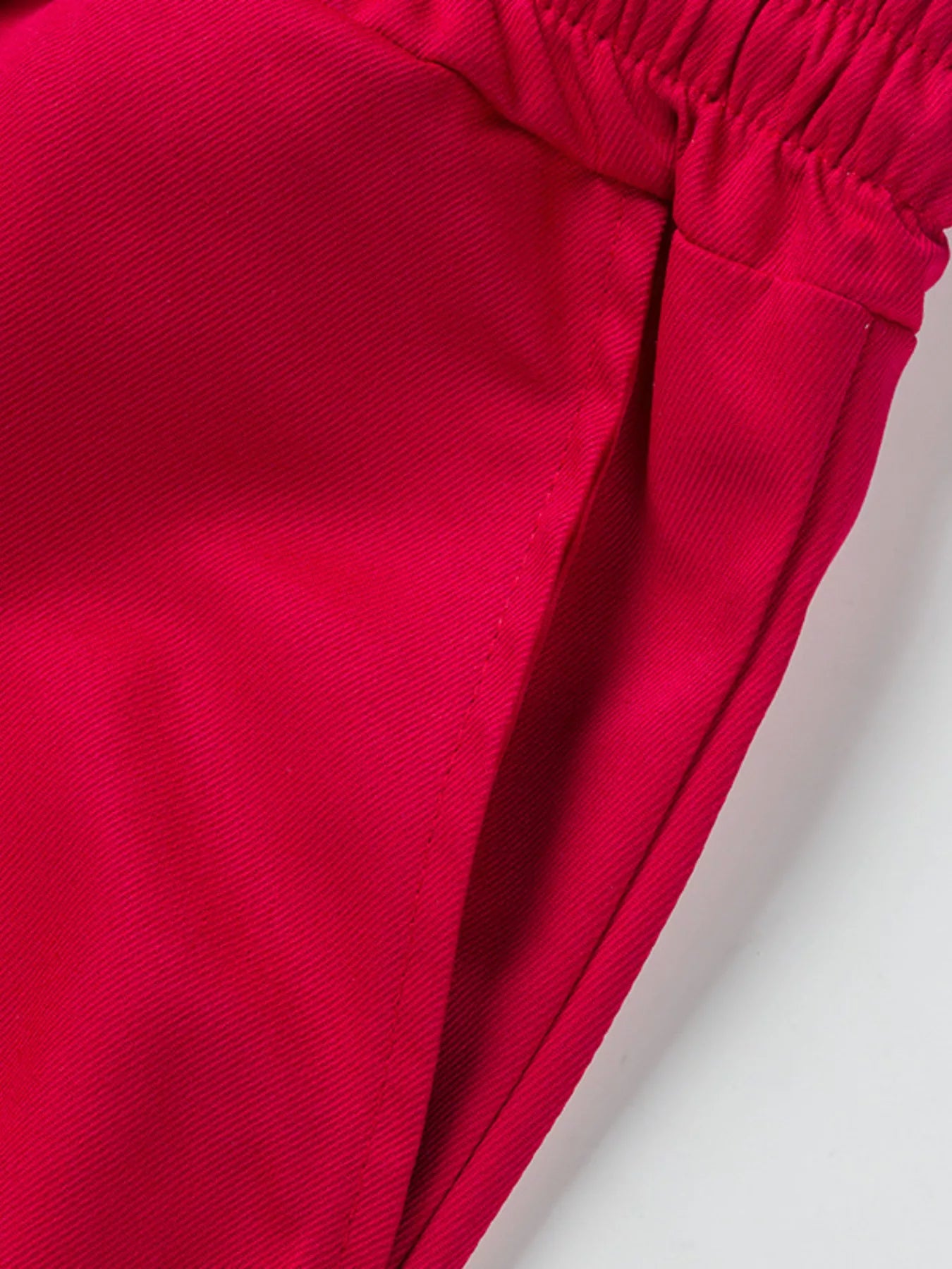 NEWYORKLISTED ATLAS MEN'S COLLECTION: Close-up of a red fabric with an elastic waistband on a light gray background