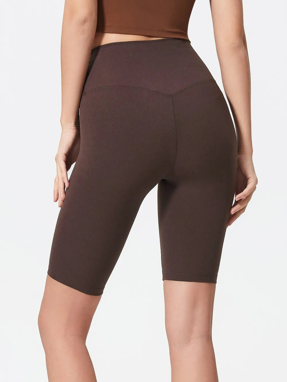 NEWYORKLISTED ACTIVEWEAR COLLECTION: Person wearing brown high-waisted shorts on a plain background