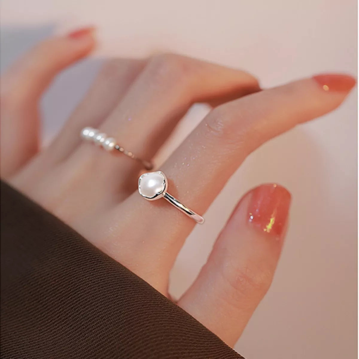 NYLD Glamour By NEWYORKLSITED: Sterling silver ring with a freshwater pearl on a hand with red nail polish