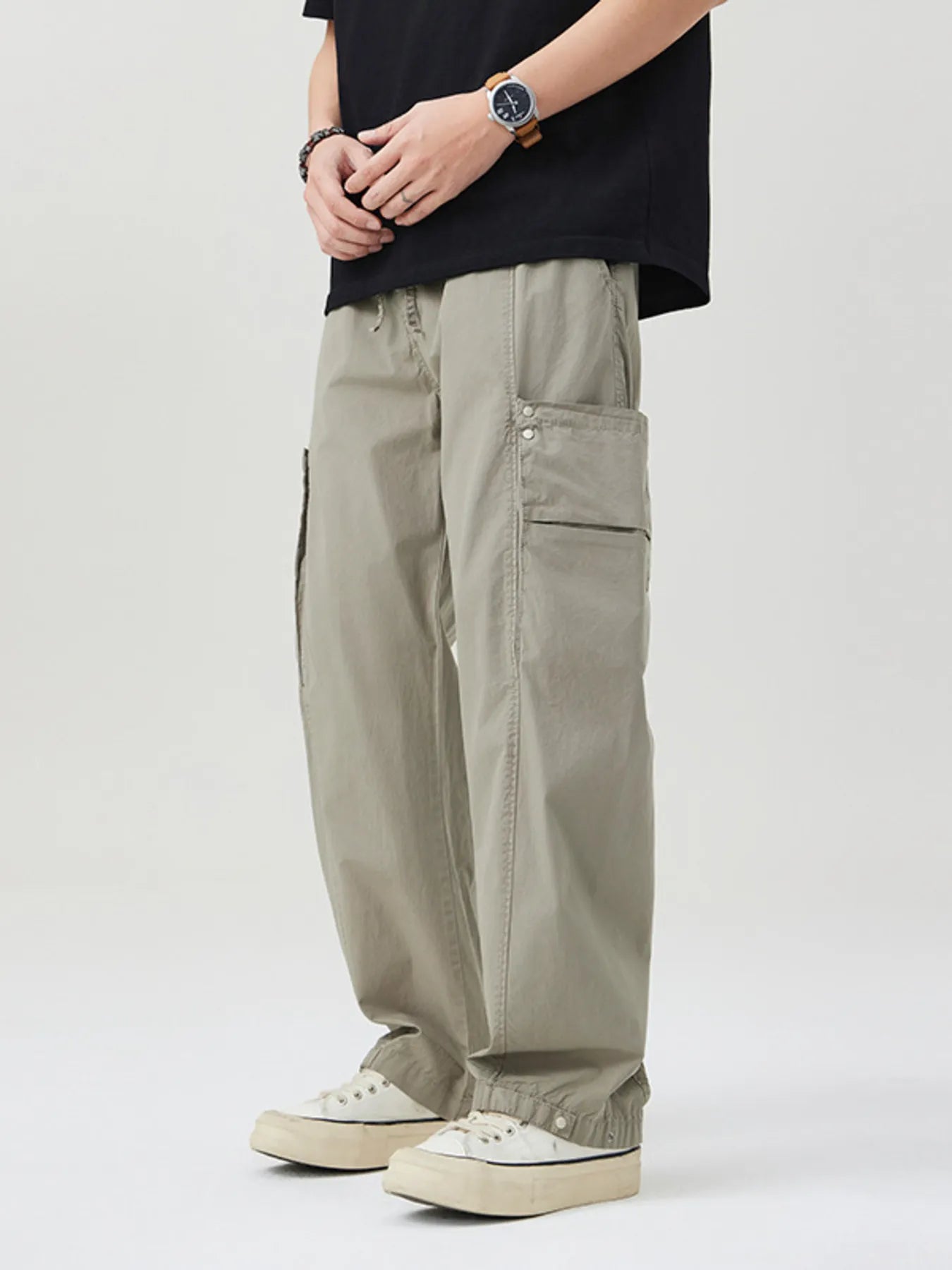 NEWYORKLISTED ATLAS MEN's COLLECTION: Person wearing beige cargo pants and a black t-shirt on a white background