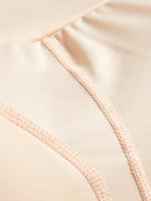 NEWYORKLISTED Intimate Apparel: Close-up of beige fabric with a focus on stitching detail