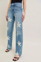 NEWYORKLISTED STYLE COLLECTION: Blue jeans with star patterns worn by a person on a plain background