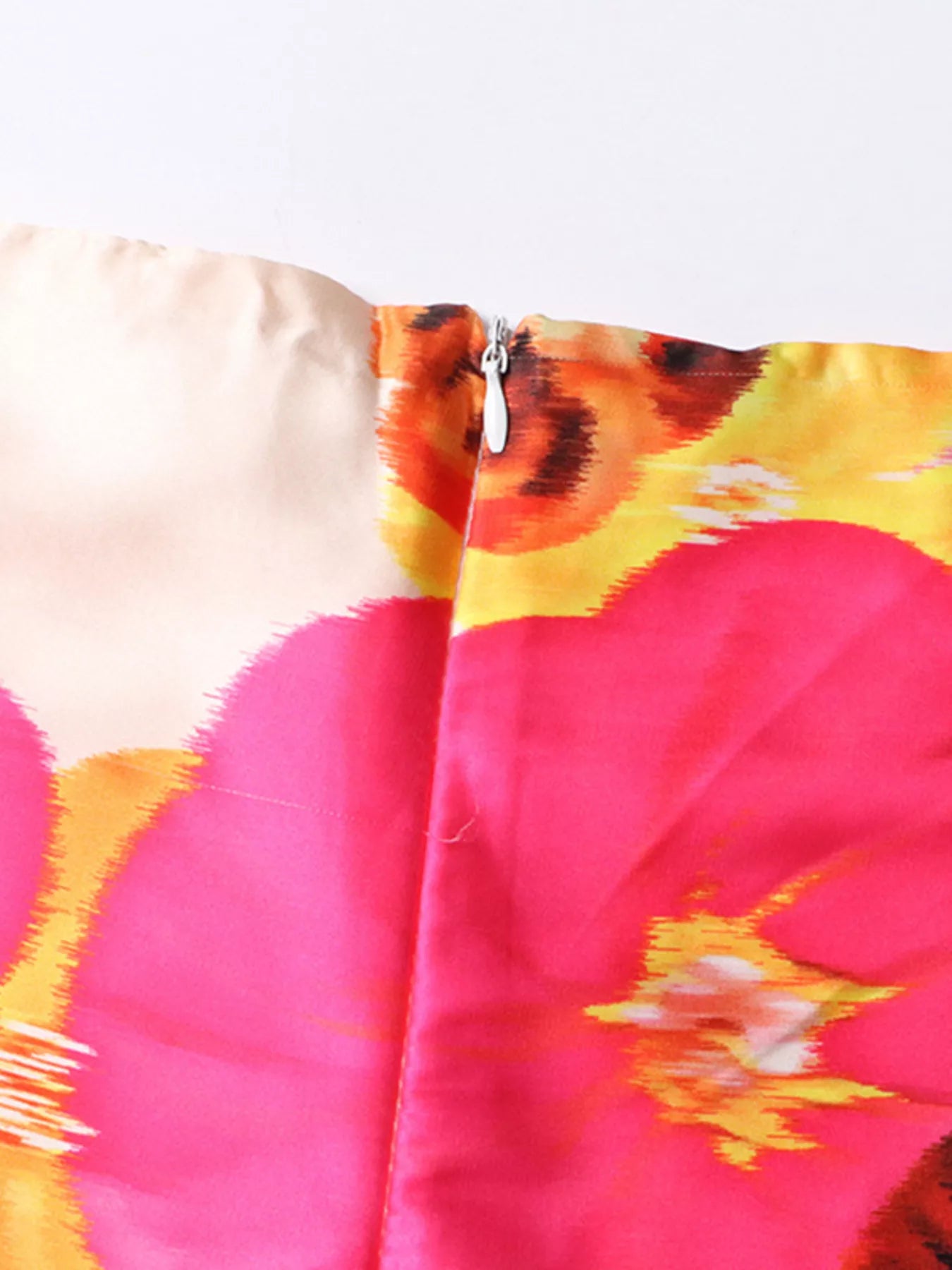 NEWYORKLSITED STYLE COLLECTION: Close-up of a colorful floral patterned fabric with pink, yellow, and orange colors.