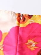 NEWYORKLSITED STYLE COLLECTION: Close-up of a colorful floral patterned fabric with pink, yellow, and orange colors.