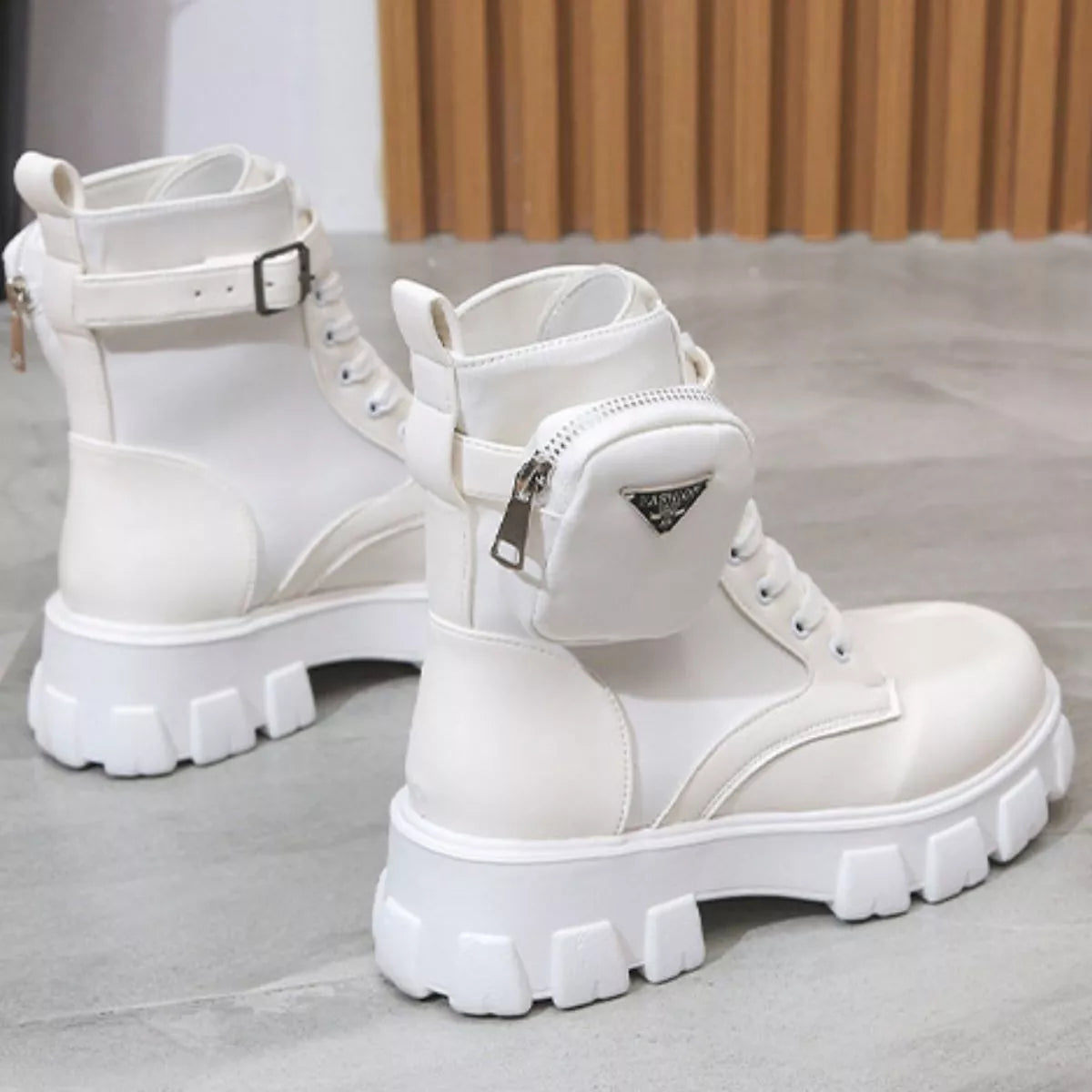 NEWYORKLISTED SHOE COLLECTION: White platform boots with zippers on a light gray floor.