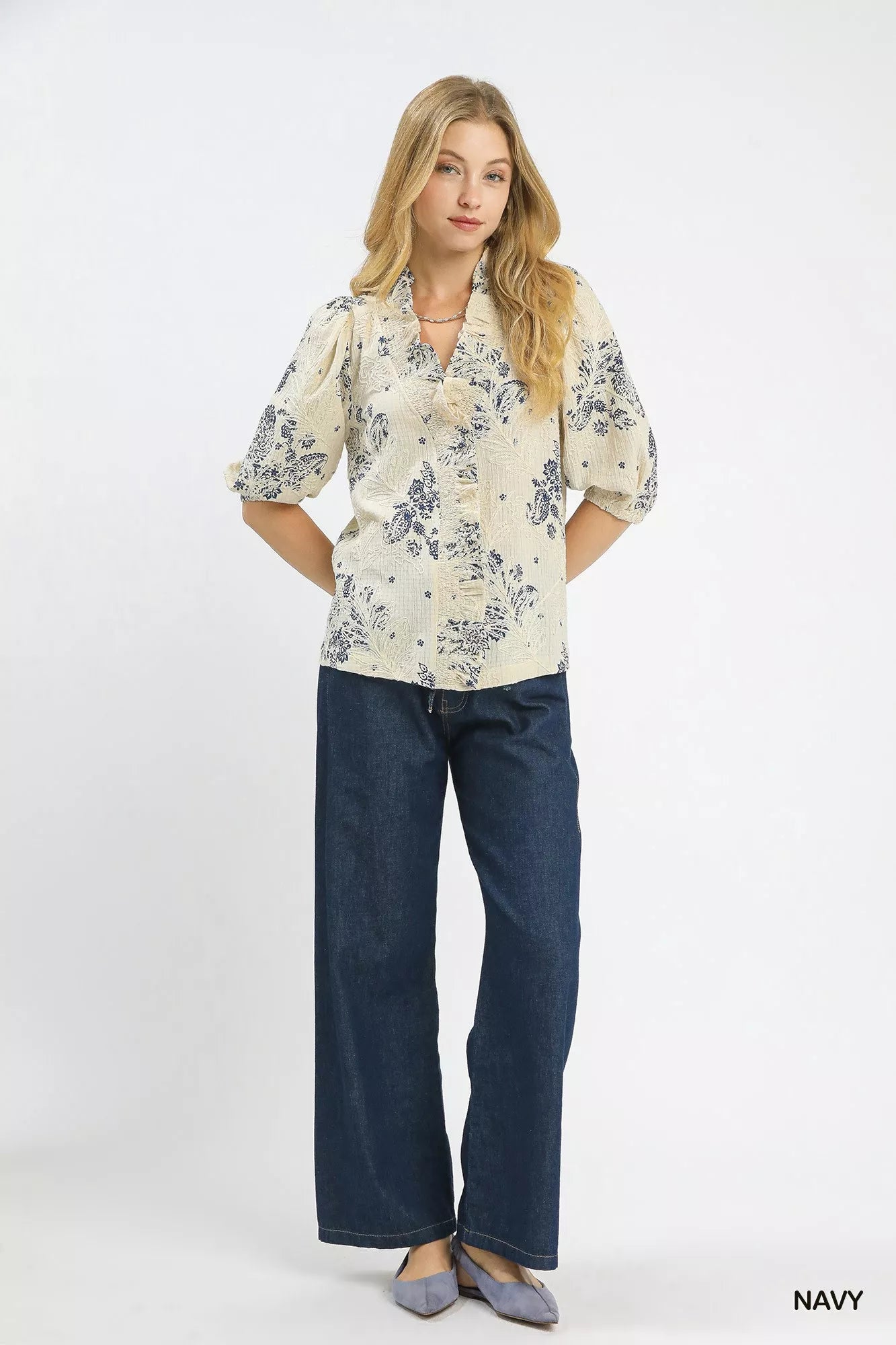 NEWYORKLISTED STYLE COLLECTION: Woman wearing a floral blouse and blue jeans on a white background