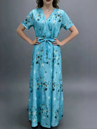 NEWYORKLISTED STYLE COLLECTION: Woman wearing a blue floral dress against a gray background