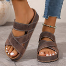 NEWYORKLISTED STYLE COLLECTION Open Toe Platform Sandals in Brown sandals worn with rolled-up jeans on a neutral background