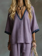 NEWYORKLISTED STYLE COLLECTION: Person wearing a purple outfit with a deep neckline against a neutral background