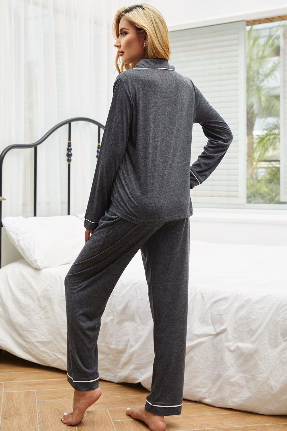 NEWYORKLISTED Intimate Apparel: Woman wearing gray pajamas standing in a bedroom.