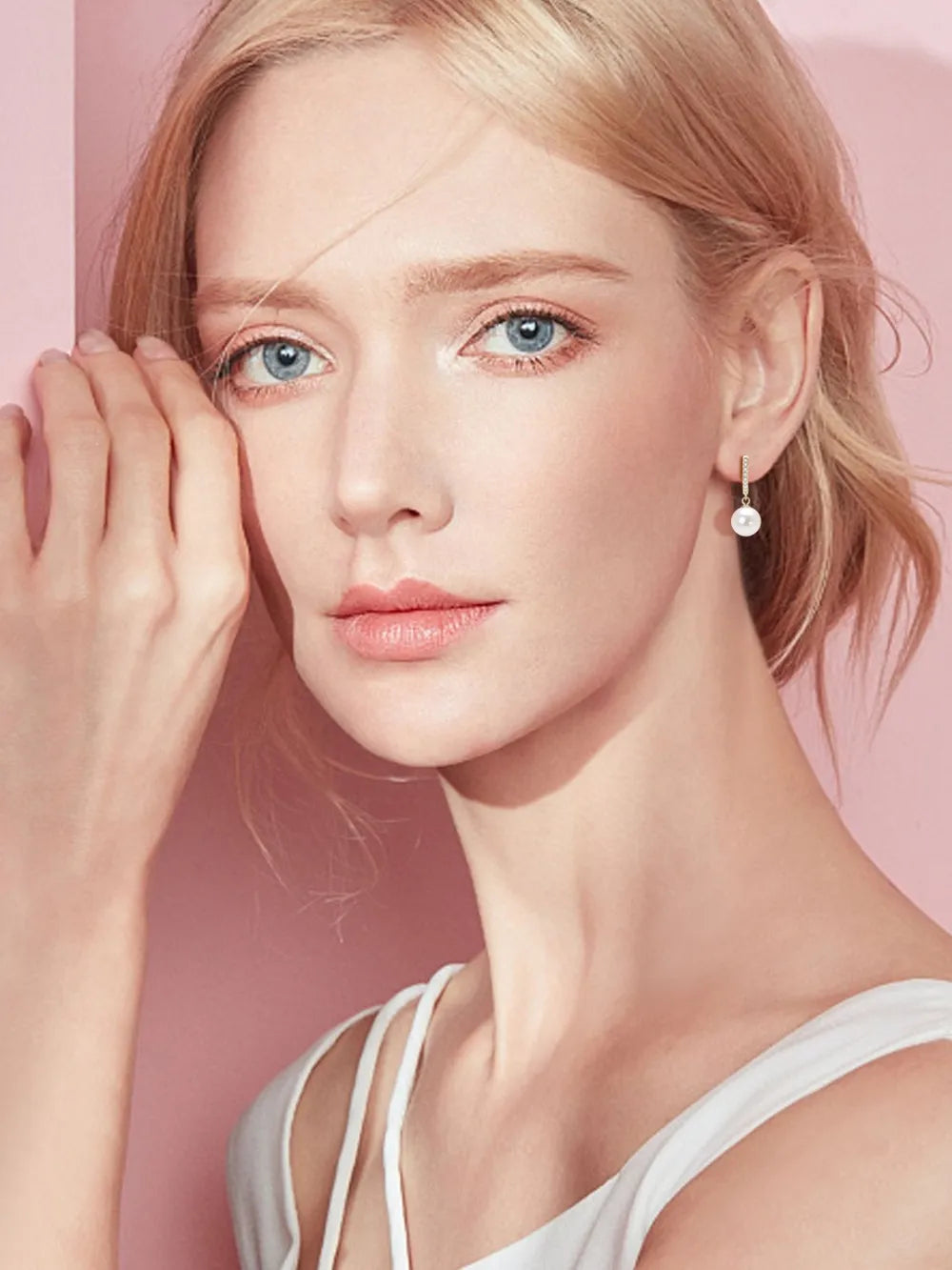 NYLD GLAMOUR COLLECTION by NEWYORKLISTED: Woman wearing a white tank top with a soft pink background