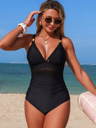 NEWYORKLISTED STYLE COLLECTION: Woman in a black swimsuit on a beach with ocean view