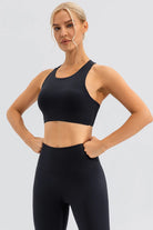 NEWYORKLISTED ACTIVEWEAR COLLECTION: Woman wearing a black sports bra and leggings on a light gray background