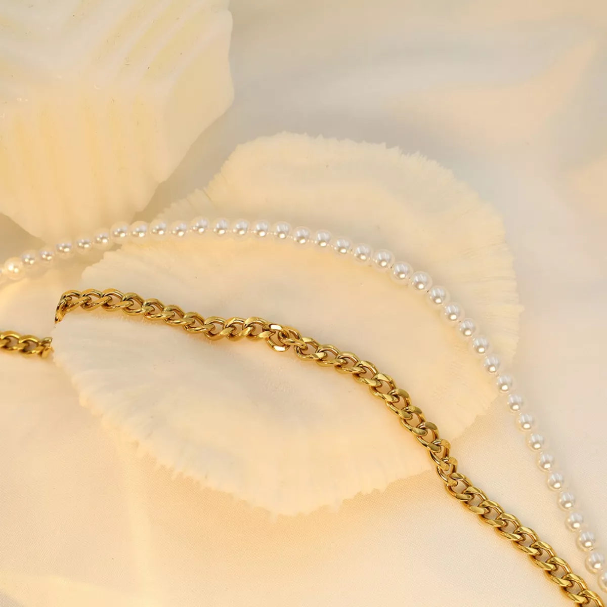 NYLD Glamour Collection by NEWYORKLISTED: Gold chain and pearl necklace on a soft beige background