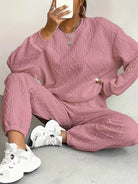 NEWYORKLISTED COMFORT COLLECTION: Person wearing a pink textured tracksuit with white sneakers on a light background